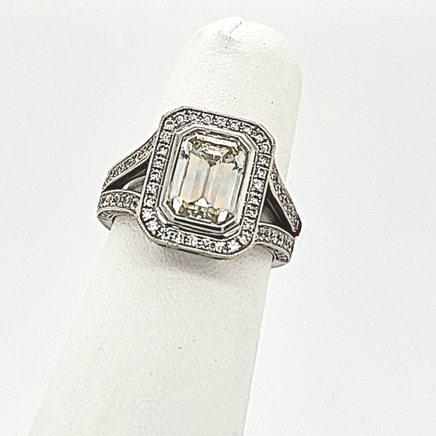 ROYAL GEMS - BEZEL SET EMERALD WITH HALO AND DIAMOND SPLIT SHANK DIAMOND RING